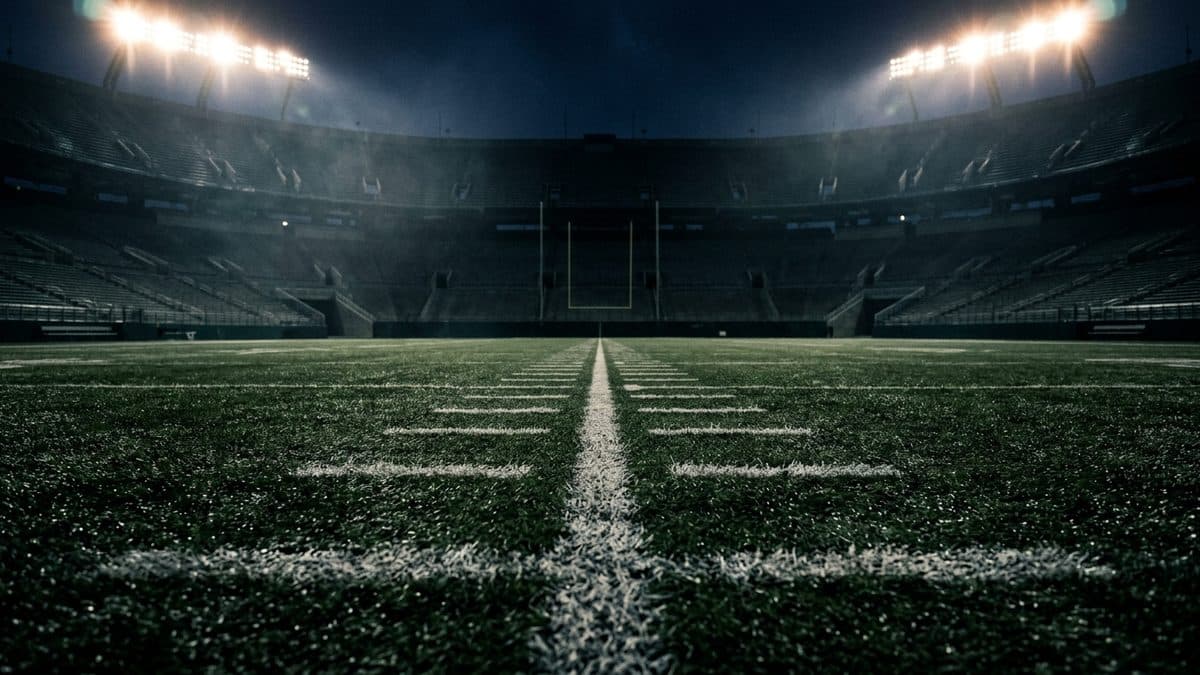 An empty football stadium under the lights before kickoff